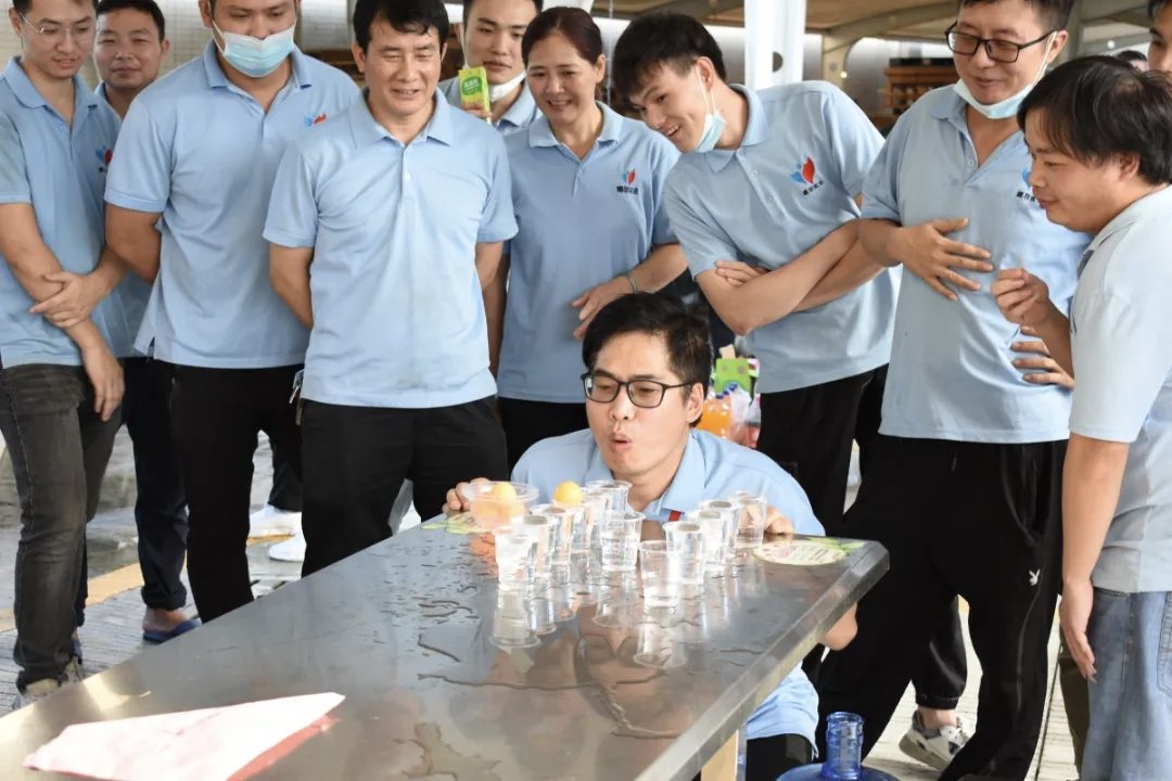 Nafei colleagues crowding around the ping-pong table at the Mid-Autumn garden party