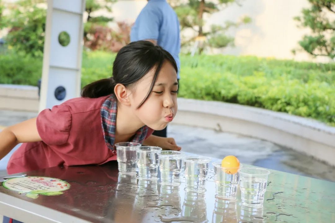 Blowing a ping-pong ball across a row of water cups