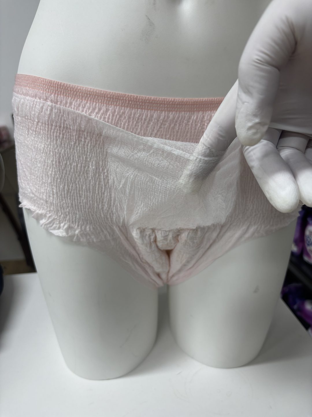 Menstrual pant sample on a fitting form, showing the warming-patch pocket sitting flat in place